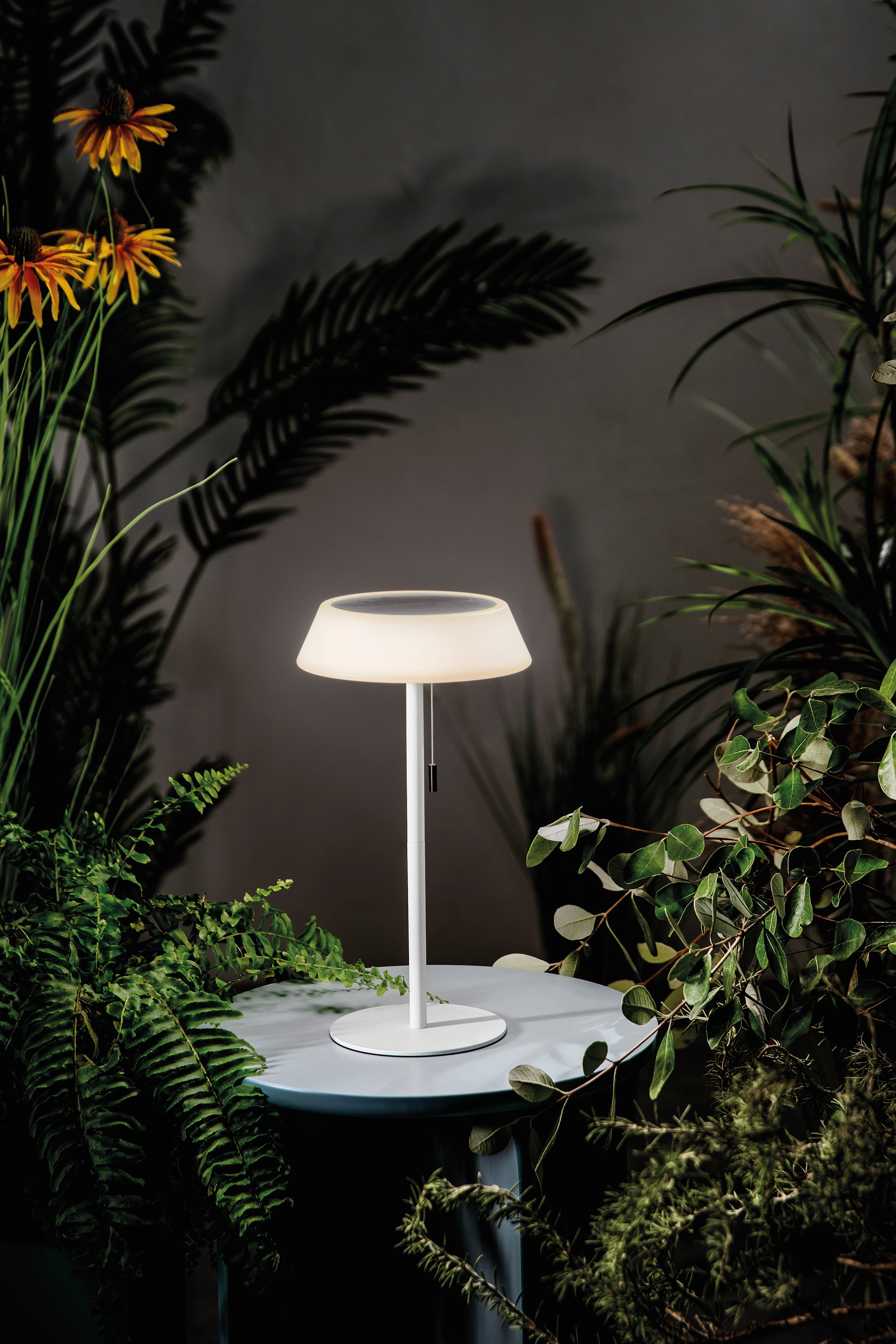 Lampada da tavolo da esterno Jin su un tavolino all'aperto